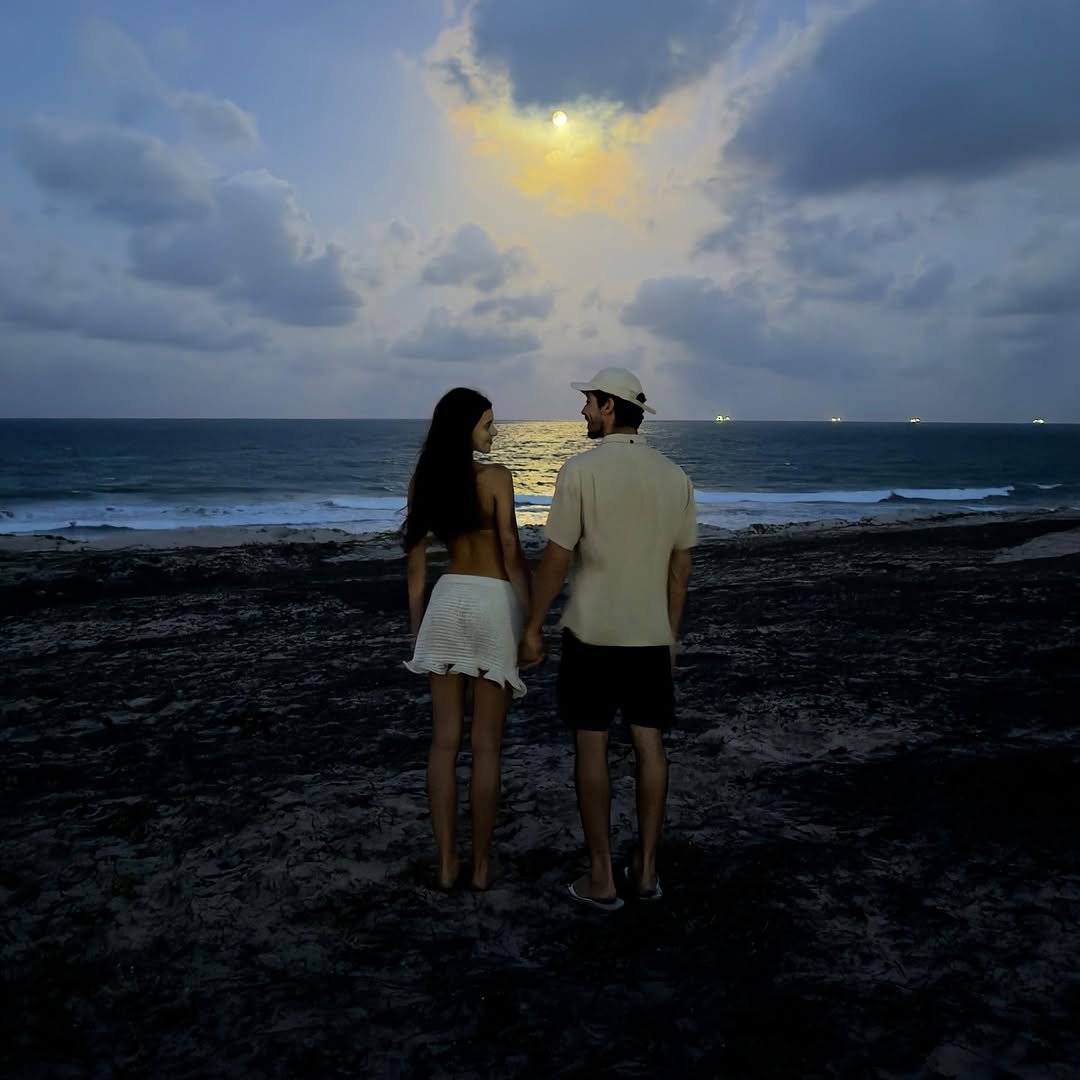 Photo by yAGO doRA on January 05, 2026. May be an image of one or more people, people kissing, twilight, beach and text.