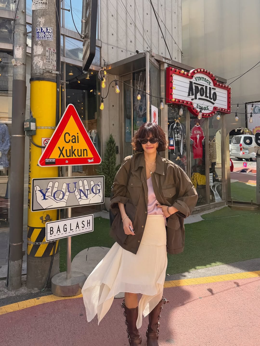 Photo by 양미라🧡미라씨 on April 23, 2026. May be an image of duffle coat, parka, signboard, street and text.