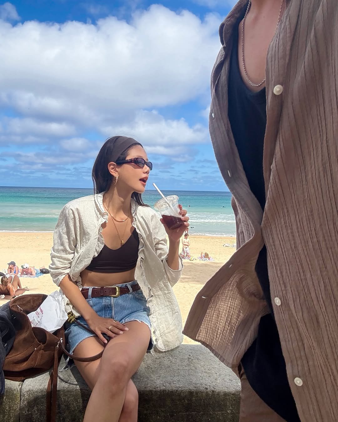 Photo shared by 예지 Yeji 🐿️ KIM on December 17, 2025 tagging @lululemonkr. May be an image of smoking, eyewear, cigarette, cigar, sarong, ocean, beach and text.