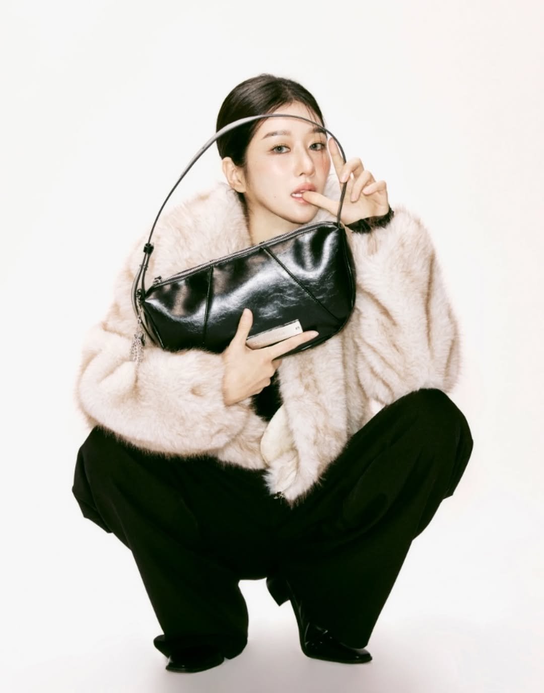 Photo by SEO YEA JI on February 01, 2026. May be an image of duffle coat, goosedown coat, fur coat, purse and text.