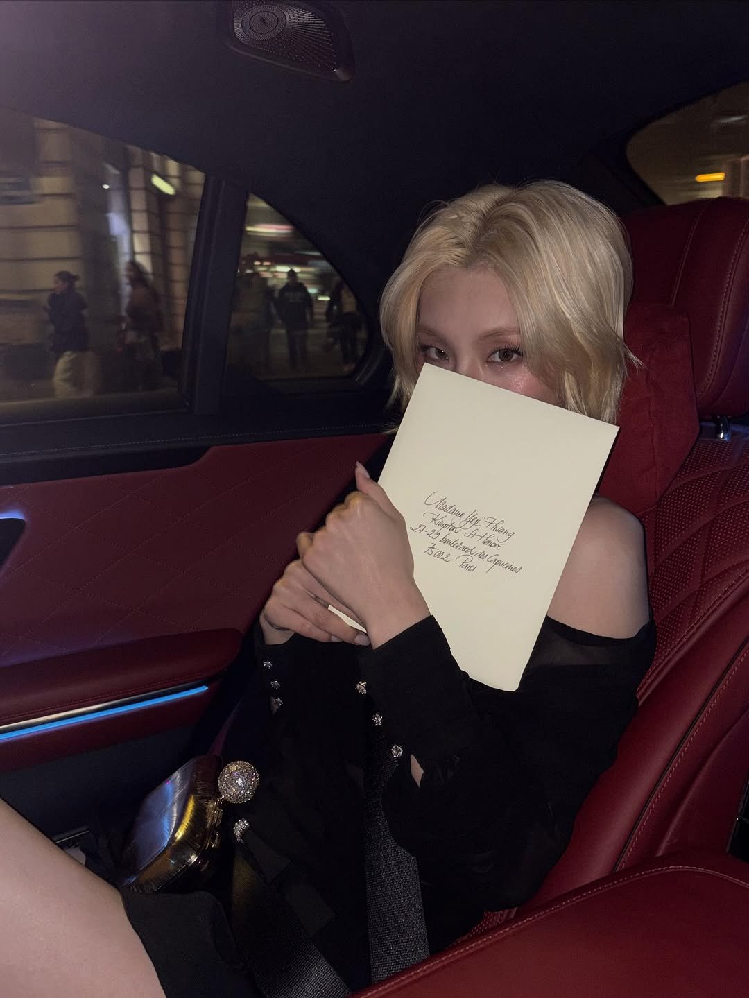 Photo shared by YEJI on October 05, 2025 tagging @rogervivier. May be an image of 1 person, book, limousine and text.