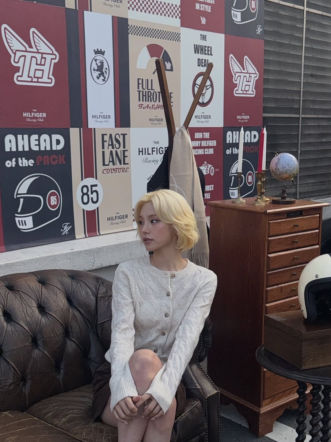Photo shared by YEJI on October 28, 2025 tagging @tommyhilfiger, and @itzy.all.in.us. May be an image of one or more people, blonde hair, parasol, cigarette and text.