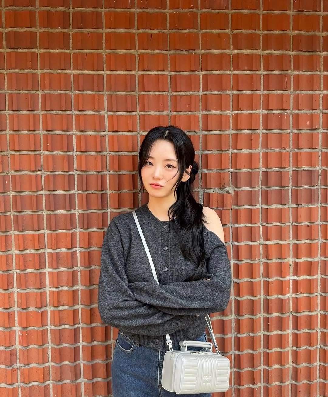 Photo by 조이현 cho yihyun on October 01, 2025. May be an image of purse, turtleneck, brick wall and text.