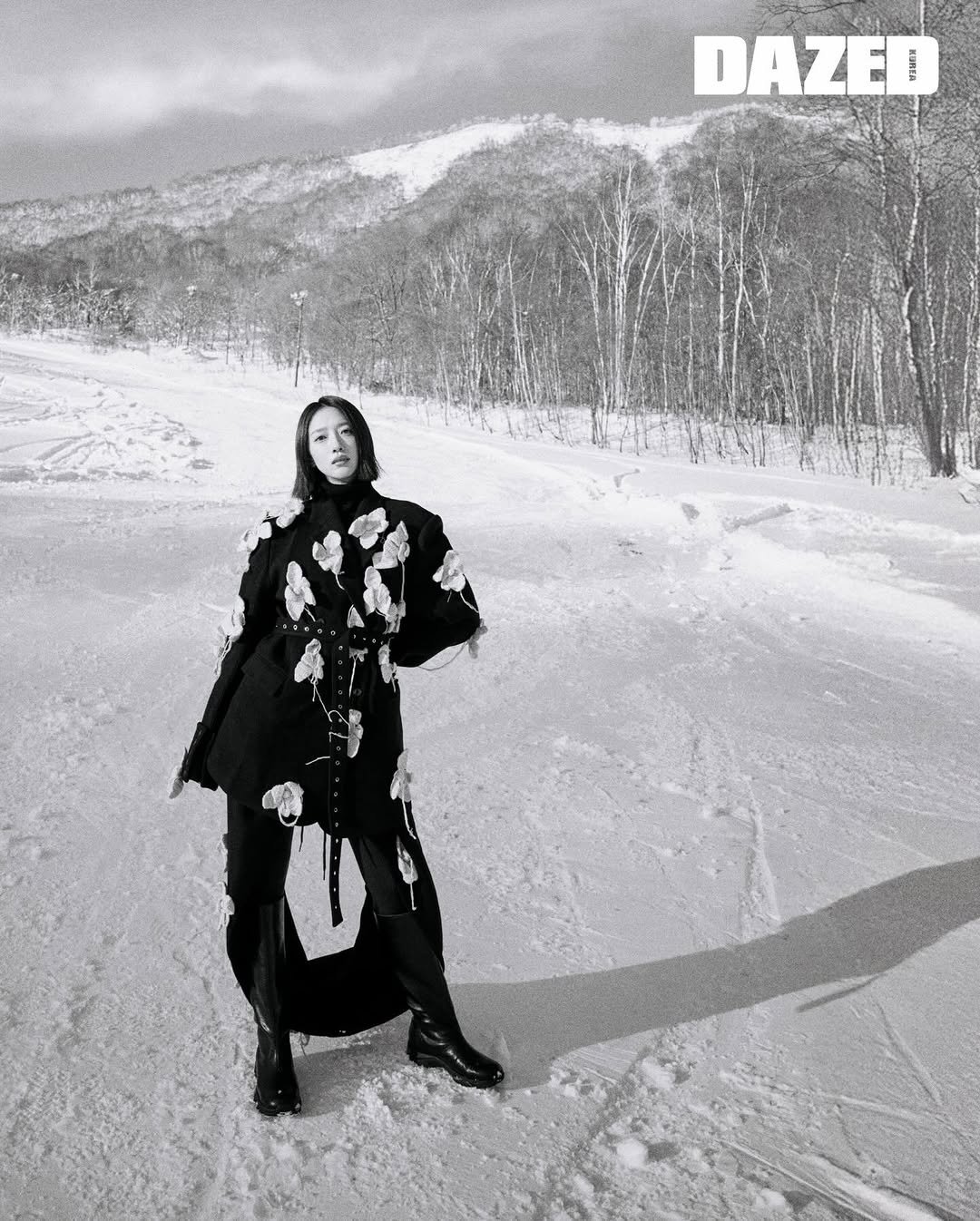 Photo by 표예진 on December 23, 2025. May be a black-and-white image of overcoat, parka, snowsuit, glasses, ski, ski slope, snow and text that says 'DAZED'.