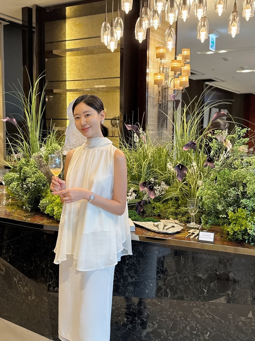 Photo shared by 오늘의 윤세 on September 25, 2025 tagging @jwmarriott_dongdaemun, and @lofa_seoul. May be an image of 1 person, flower arrangement, overskirt, prairie gentian, white lily and text.