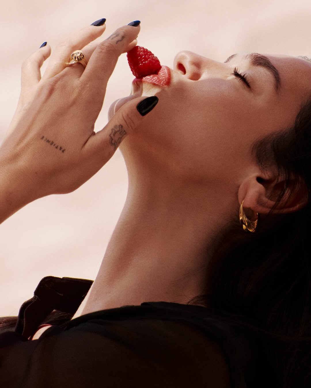 Photo shared by YSL Beauty Official on January 13, 2026 tagging @dualipa. May be an image of one or more people, makeup, cigarette, pomegranate, strawberry and text.