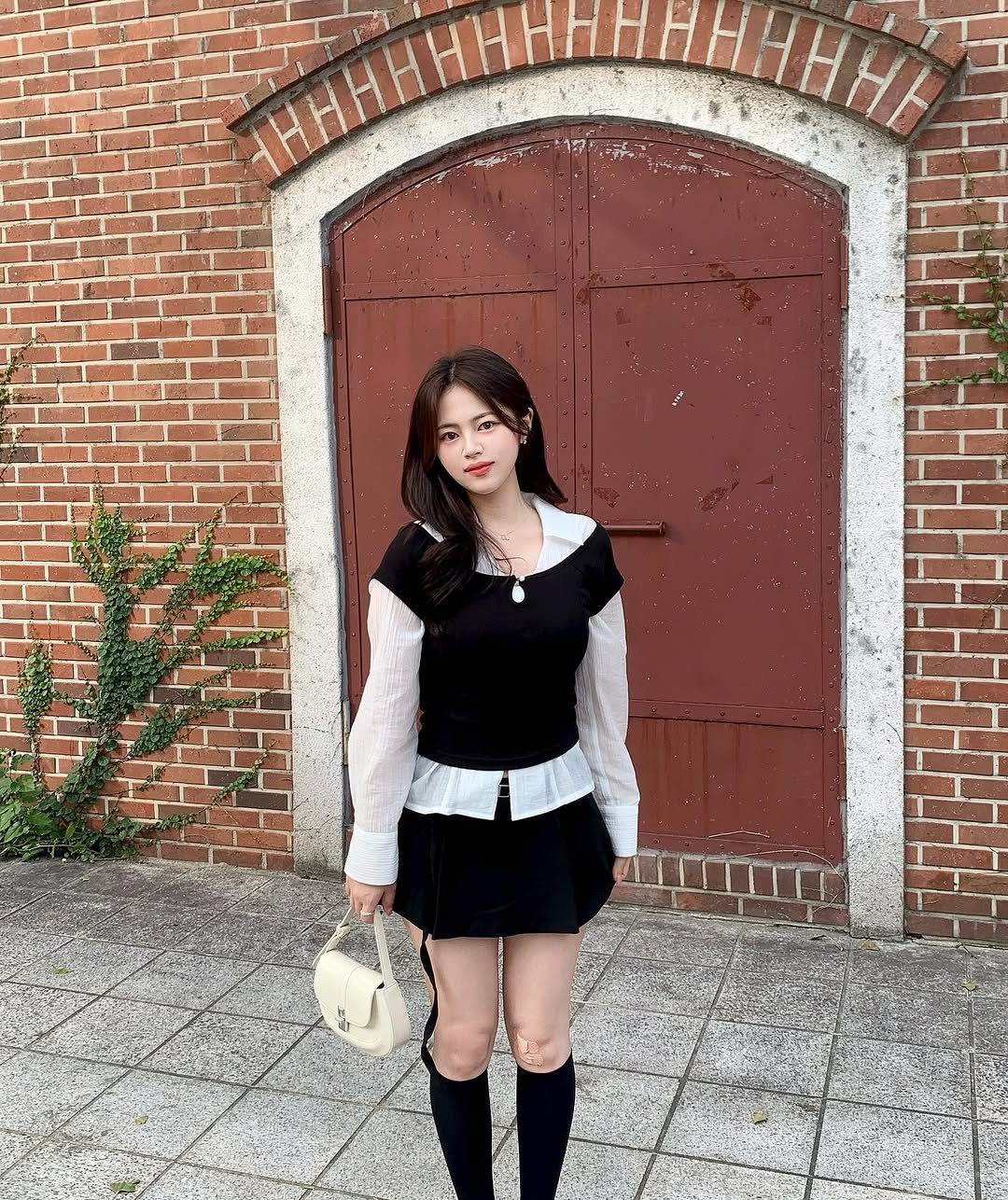 Photo by 윤하짱 ⸜❤︎⸝‍ ​| 소프트라인 on September 01, 2025. May be an image of 1 person, dirndl, bowler hat, miniskirt, cloak, brick wall and text.