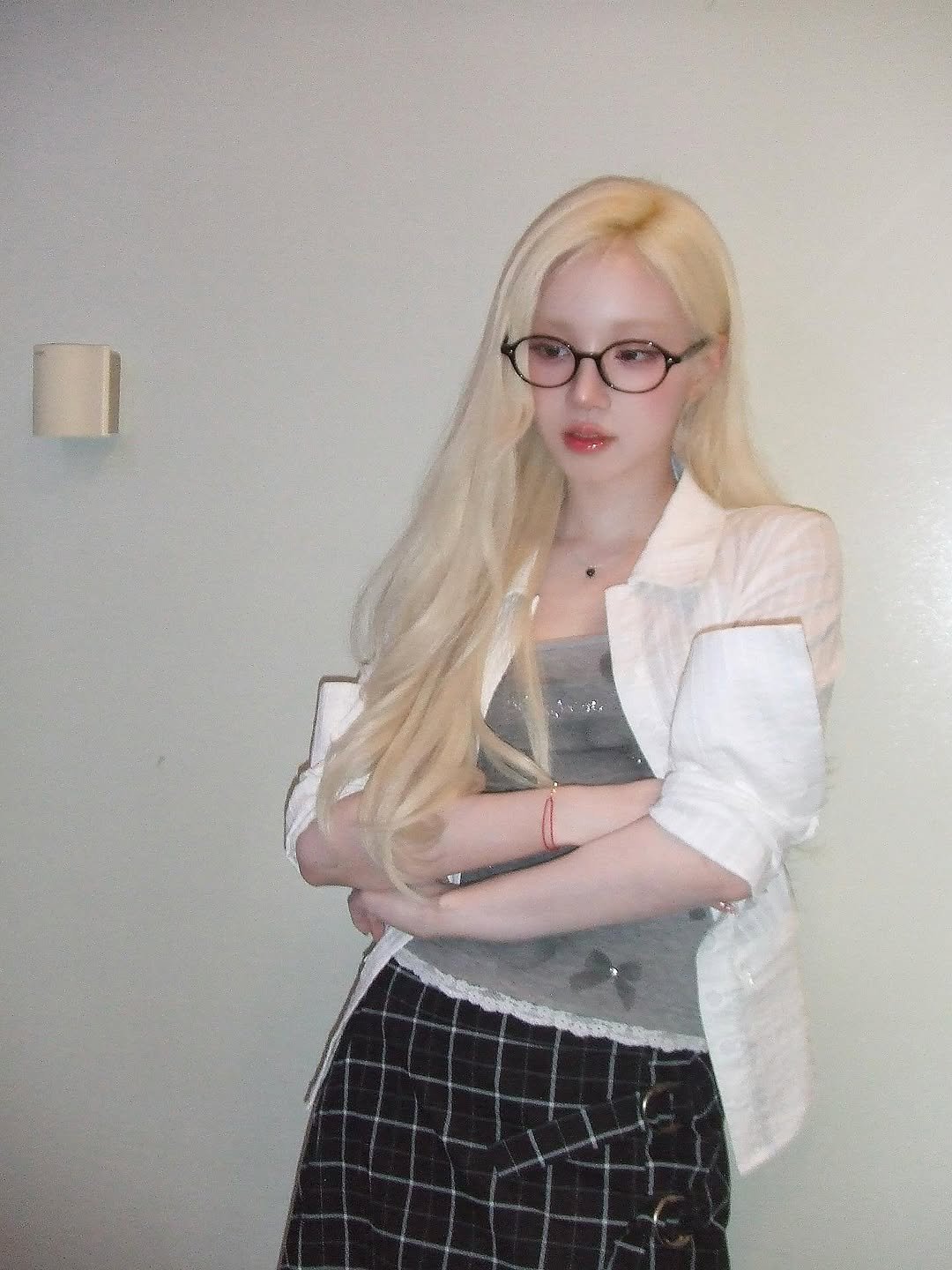 Photo by YUQI on June 22, 2025. May be an image of 1 person, bangs, blonde hair, eyeglasses, blazer, suit, miniskirt and text.