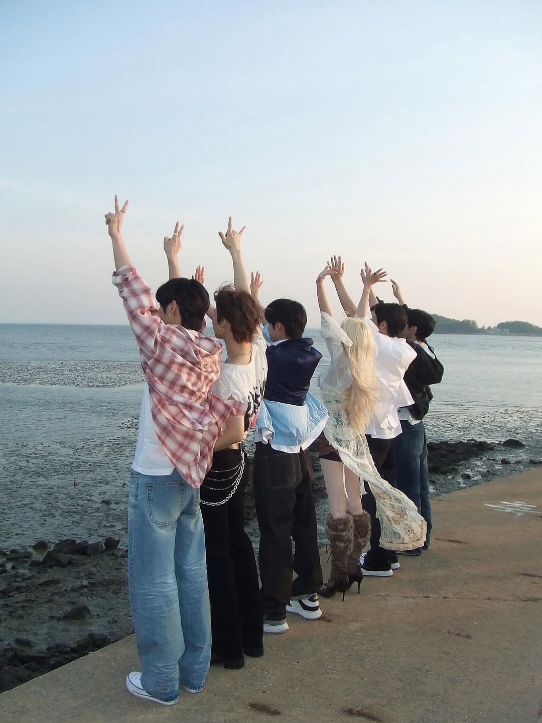 Photo shared by YUQI on June 17, 2025 tagging @nowz_official. May be an image of 5 people, beach, ocean and text.