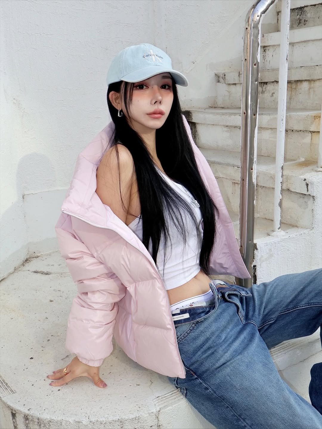 Photo shared by 유라 (李유라) on November 18, 2025 tagging @calvinklein. May be an image of hat, duffle coat and goosedown coat.