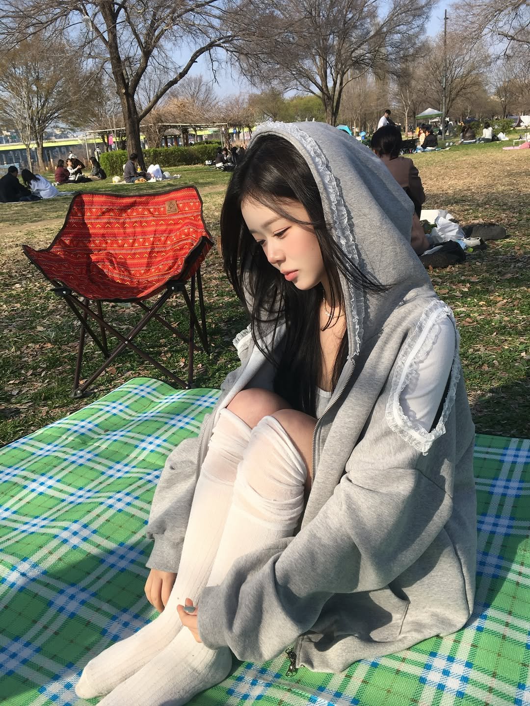 Photo shared by 홍유연 on April 06, 2026 tagging @u_bion_. May be an image of duffle coat, cloak, parka, grass, picnic, park and text.