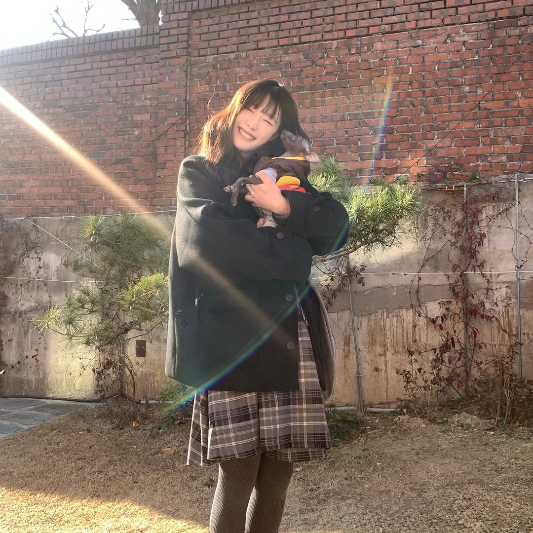 Photo by 하랑 on January 04, 2026. May be an image of duffle coat, overcoat, parka, beret, turtleneck, brick wall and text.