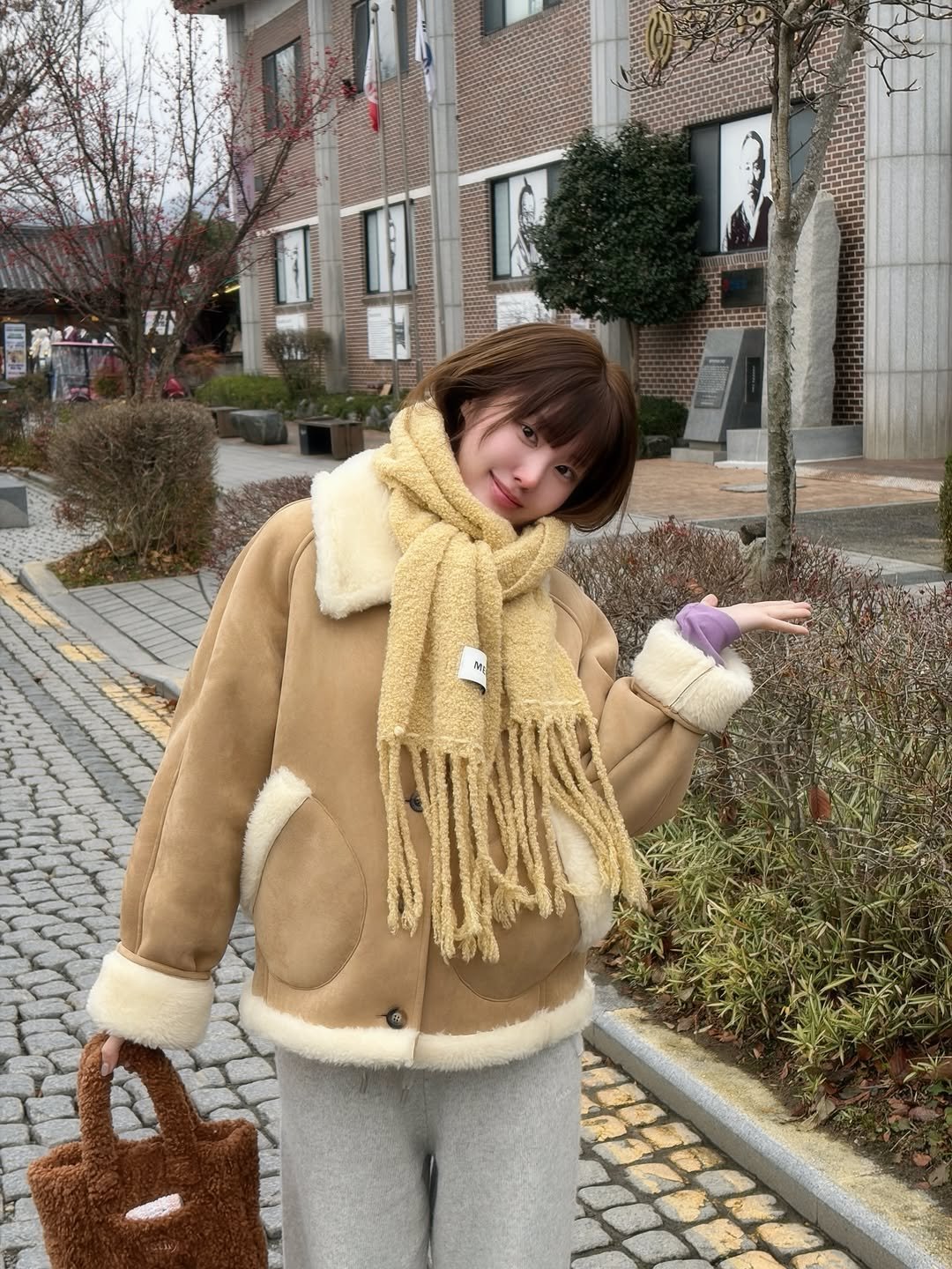Photo shared by 하여니 on December 17, 2025 tagging @meenderi_official. May be an image of duffle coat, overcoat, scarf, goosedown coat, purse, parka and text.
