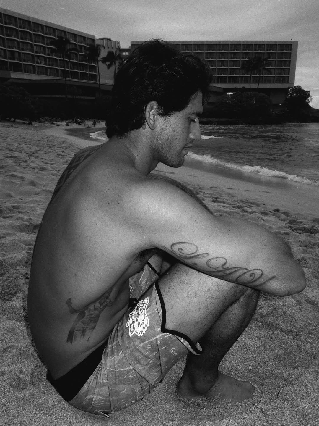 Photo shared by Zeke Lau on February 20, 2026 tagging @darcsportathletics. May be a black-and-white image of one or more people, tattoo, beach, ocean and text.