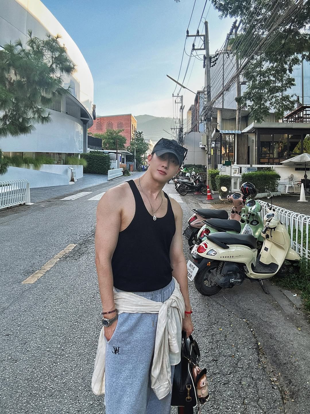 Photo by ZHOUMI 조미 周觅 on November 19, 2025. May be an image of one or more people, biceps, segway, scooter, sarong, tanktop, street and text.