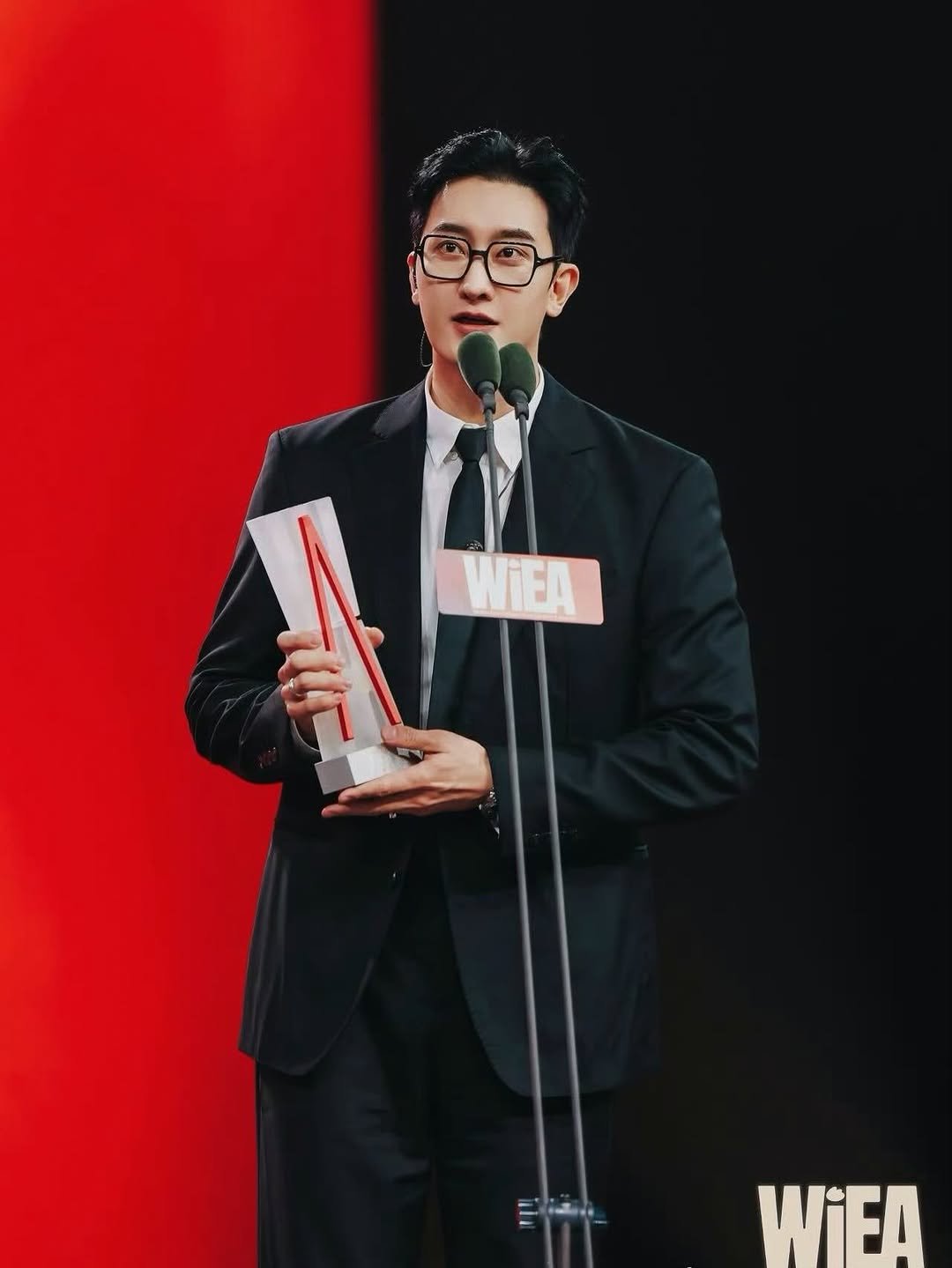 Photo by ZHOUMI 조미 周觅 on April 26, 2026. May be an image of bolo tie, suit, microphone, blazer, dinner jacket and text that says 'WIEA WIEA'.