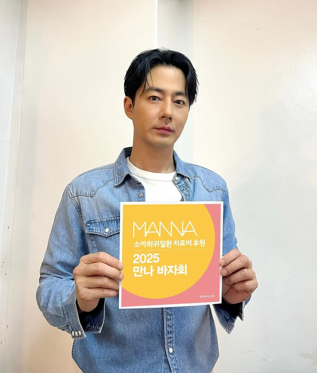 Photo shared by 조인성 on October 12, 2025 tagging @manna_you. May be an image of one or more people, hair, poster, top and text that says 'MANNA 소아희귀질환치료비후원 치료 소아희귀질환 2025 만나 바지 바자회 CTAELRe'.
