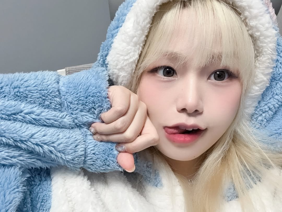 Photo by 자용이 on November 25, 2025. May be an image of one or more people, blonde hair, bath robe, parka and text.